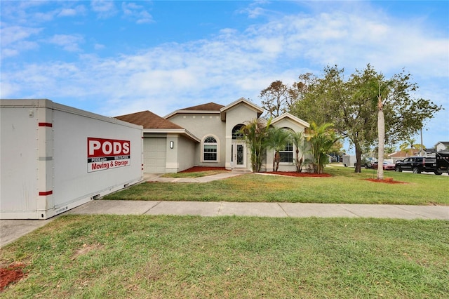 mediterranean / spanish-style home with a garage, stucco siding, and a front yard