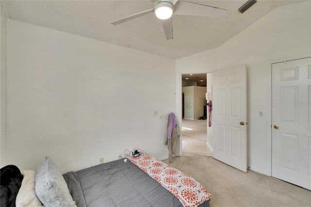 bedroom featuring light carpet, vaulted ceiling, visible vents, and ceiling fan