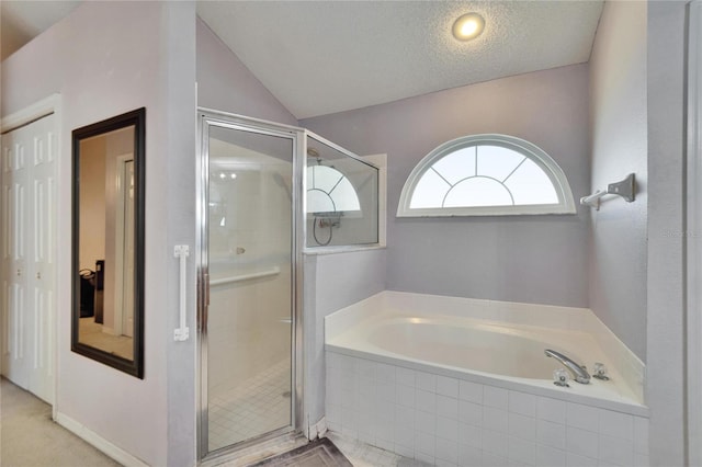 bathroom featuring lofted ceiling, a shower stall, a textured ceiling, and a bath