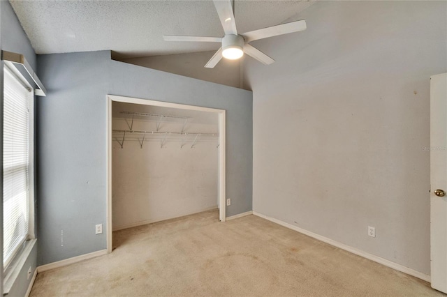 unfurnished bedroom featuring baseboards, vaulted ceiling, a textured ceiling, carpet floors, and a closet