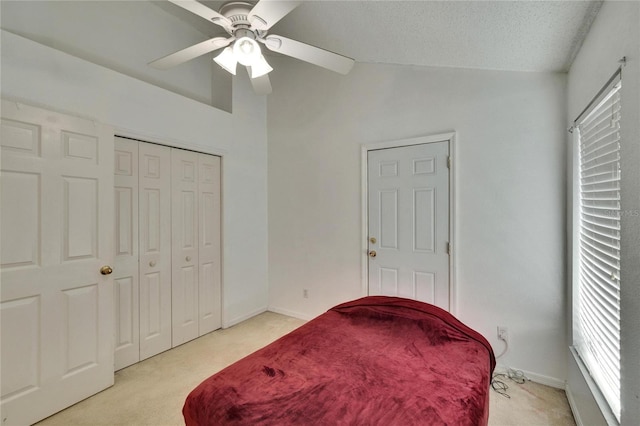 bedroom featuring light colored carpet, vaulted ceiling, a textured ceiling, ceiling fan, and baseboards