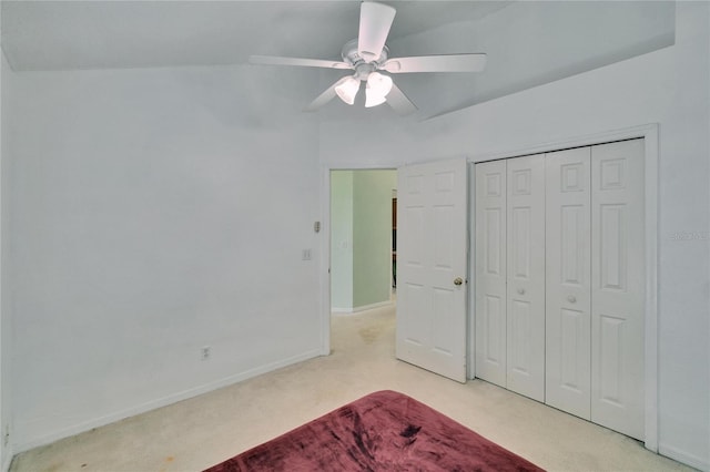 unfurnished bedroom featuring a ceiling fan, a closet, light colored carpet, and baseboards