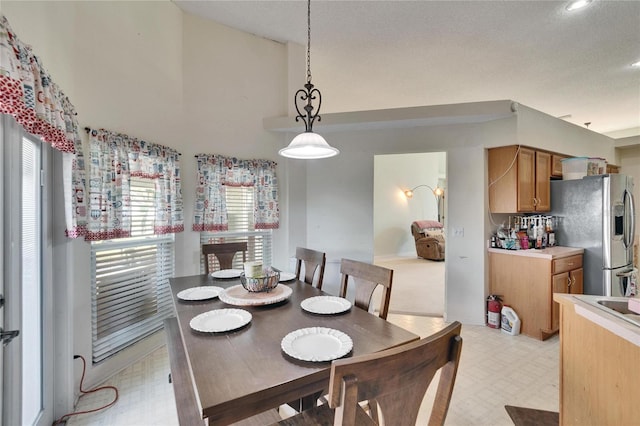 dining area with a high ceiling and light floors