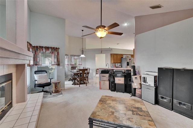 kitchen with stainless steel fridge, visible vents, light colored carpet, ceiling fan, and high vaulted ceiling