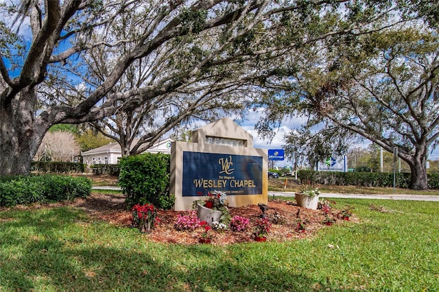 community / neighborhood sign with a yard