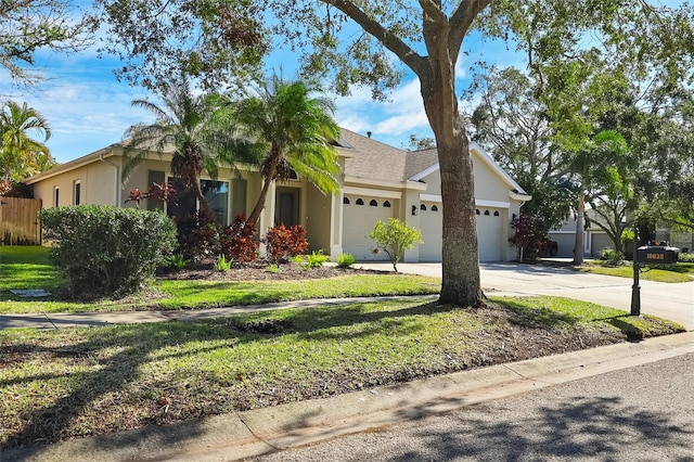 view of front of property featuring driveway, roof with shingles, an attached garage, fence, and stucco siding