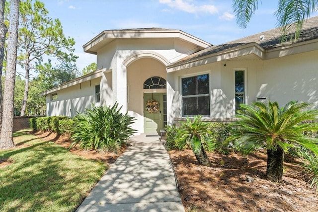 doorway to property featuring stucco siding