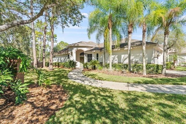 mediterranean / spanish-style house featuring a front lawn and stucco siding