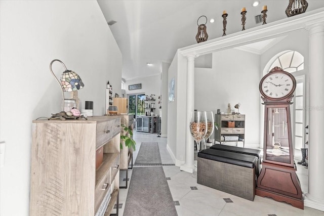 foyer entrance with visible vents, crown molding, and decorative columns