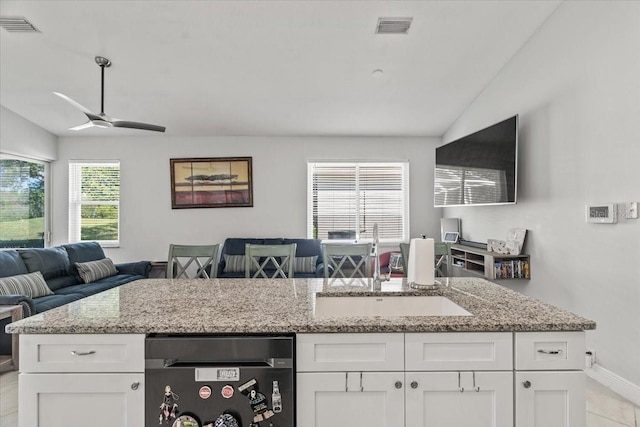 kitchen featuring vaulted ceiling, visible vents, open floor plan, and a sink