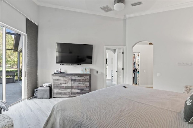 bedroom with access to exterior, crown molding, arched walkways, and visible vents