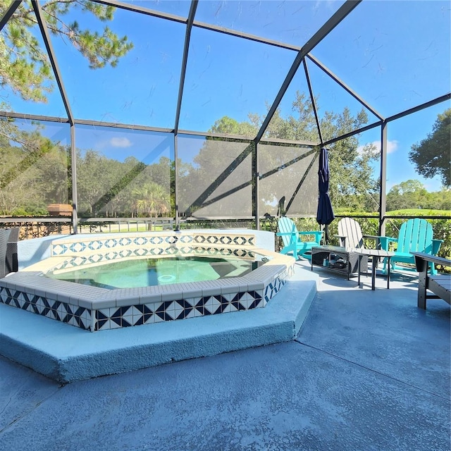 view of patio / terrace featuring an in ground hot tub and a lanai