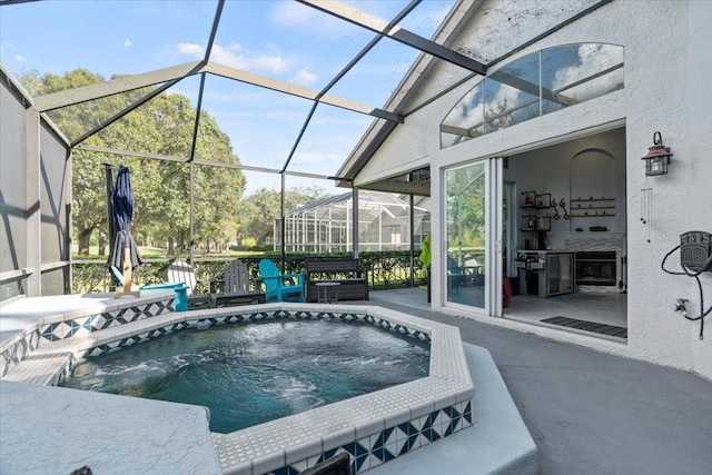 view of swimming pool with a jacuzzi, glass enclosure, and a patio area