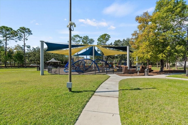 view of home's community featuring playground community and a yard