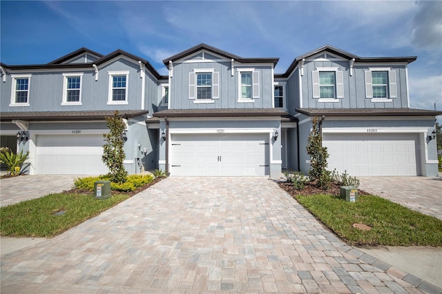 view of front of home with a garage, decorative driveway, and board and batten siding