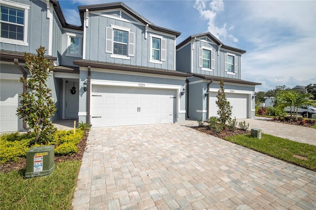 view of front of property with board and batten siding, decorative driveway, and a garage