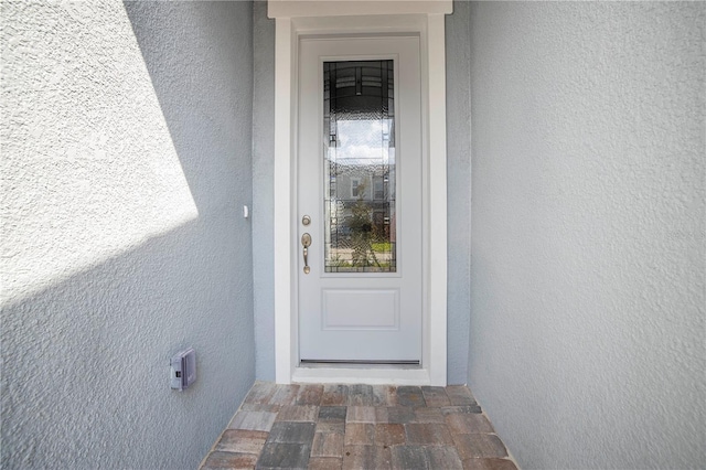 property entrance with stucco siding