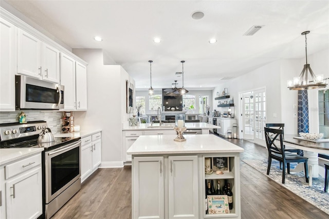 kitchen featuring stainless steel appliances, light countertops, visible vents, backsplash, and a sink