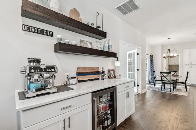 bar featuring wine cooler, pendant lighting, a dry bar, visible vents, and dark wood-type flooring