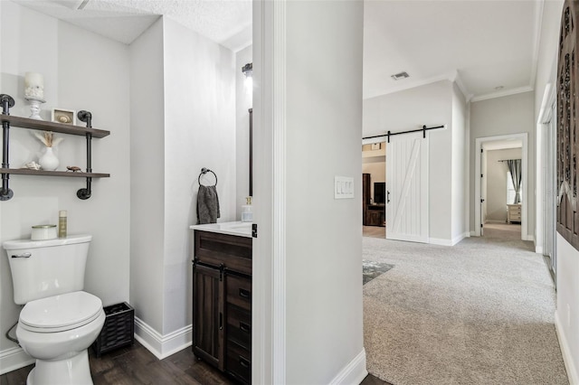 bathroom with crown molding, visible vents, toilet, vanity, and baseboards