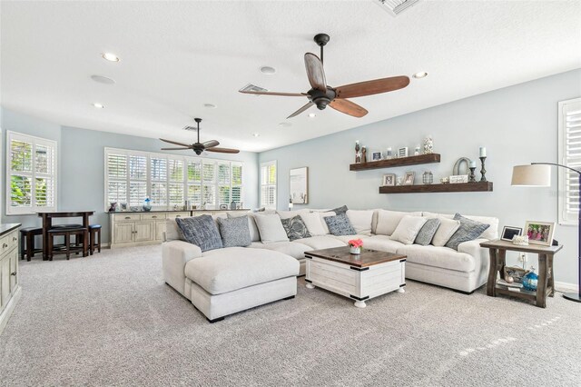 living area featuring light carpet, a healthy amount of sunlight, and recessed lighting