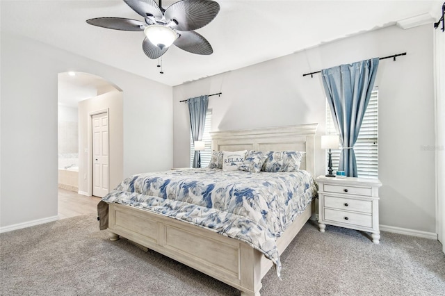 bedroom with carpet, arched walkways, baseboards, and ensuite bathroom