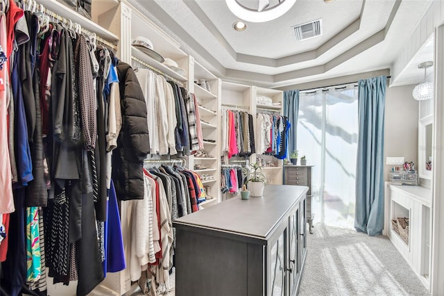 walk in closet featuring a tray ceiling, carpet, and visible vents