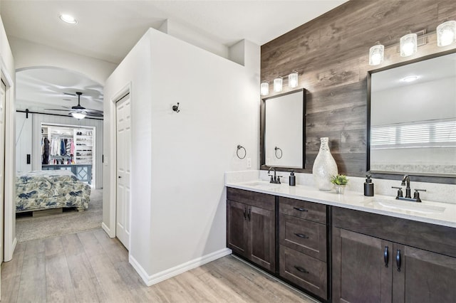 bathroom featuring ensuite bathroom, ceiling fan, wood finished floors, and a sink