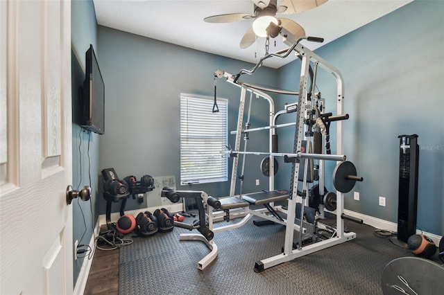 workout room featuring ceiling fan, baseboards, and wood finished floors