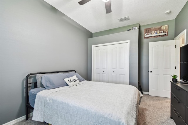 bedroom featuring baseboards, visible vents, a ceiling fan, light colored carpet, and a closet