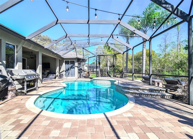 view of pool with glass enclosure, a grill, and a patio