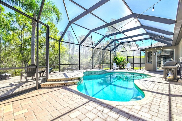 pool featuring a lanai, a patio area, and a grill