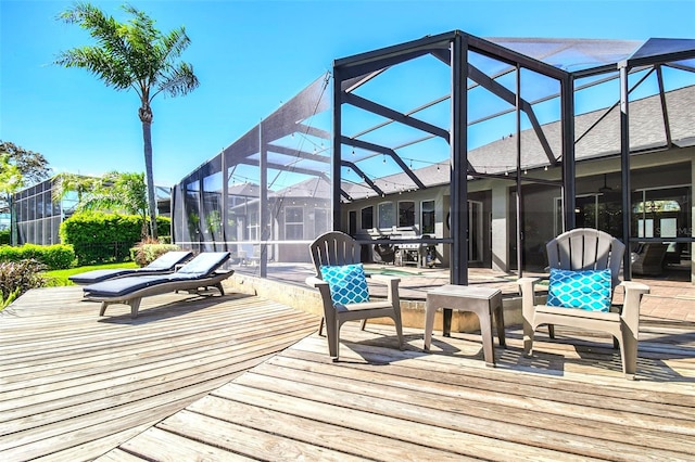 wooden deck with a lanai and an outdoor pool