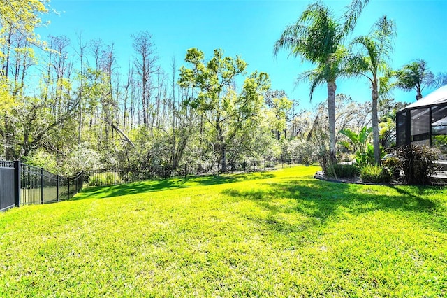 view of yard with a lanai and a fenced backyard