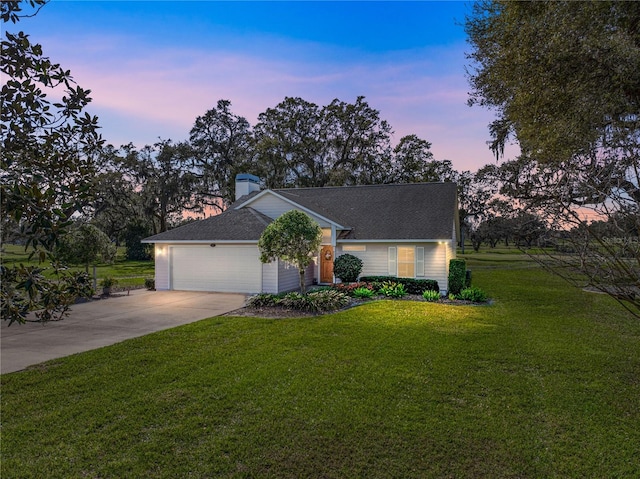 view of front of house with driveway, a garage, a chimney, and a front lawn