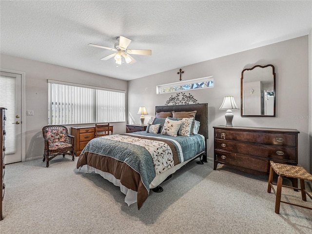 carpeted bedroom featuring a textured ceiling, multiple windows, baseboards, and a ceiling fan