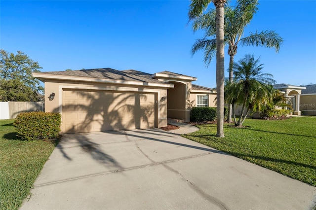 view of front facade with driveway, a front yard, an attached garage, and stucco siding