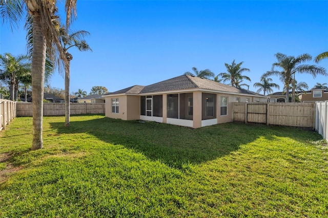 view of yard featuring a sunroom and a fenced backyard