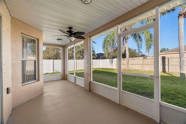 unfurnished sunroom featuring a ceiling fan and a healthy amount of sunlight