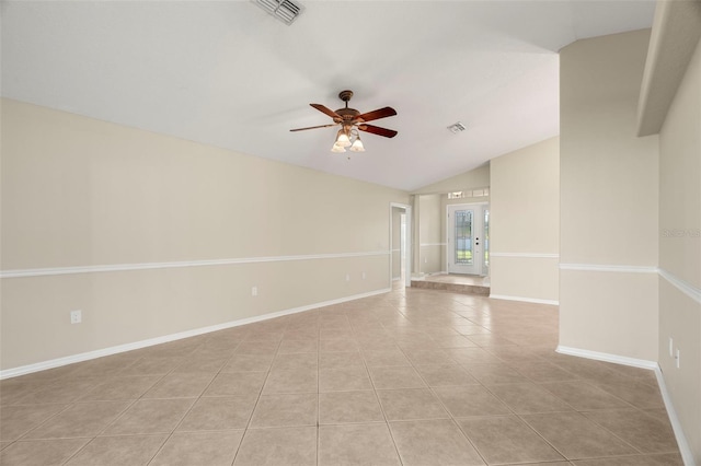 empty room featuring vaulted ceiling, light tile patterned floors, visible vents, and baseboards