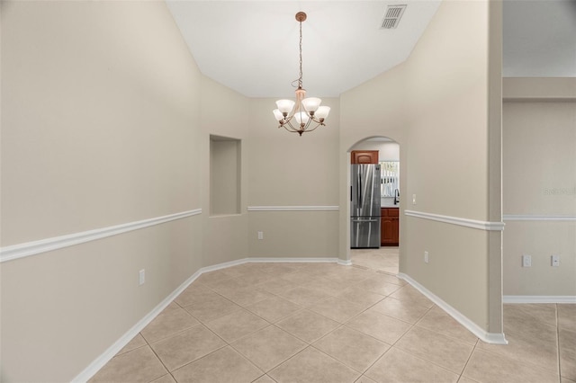 unfurnished room featuring light tile patterned floors, arched walkways, visible vents, baseboards, and an inviting chandelier