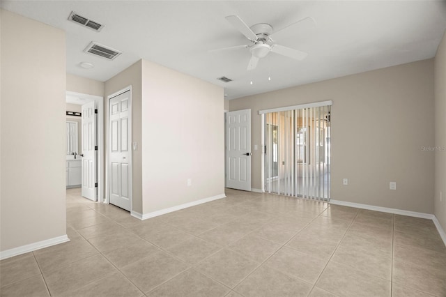 empty room with baseboards, visible vents, and light tile patterned flooring