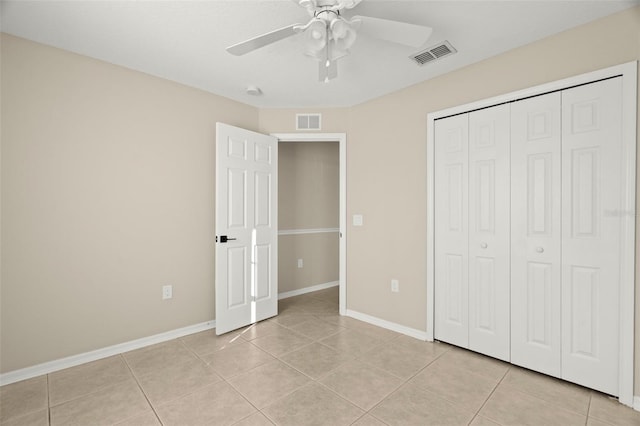 unfurnished bedroom with light tile patterned floors, baseboards, visible vents, and a closet