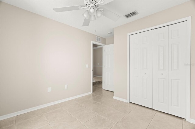 unfurnished bedroom featuring light tile patterned floors, a closet, visible vents, and baseboards