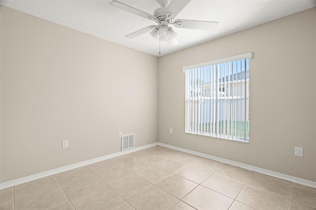 spare room featuring a ceiling fan, visible vents, baseboards, and light tile patterned flooring