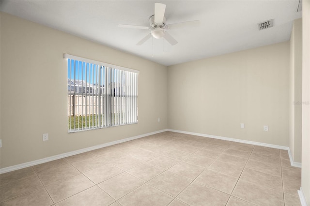 spare room with light tile patterned floors, ceiling fan, visible vents, and baseboards