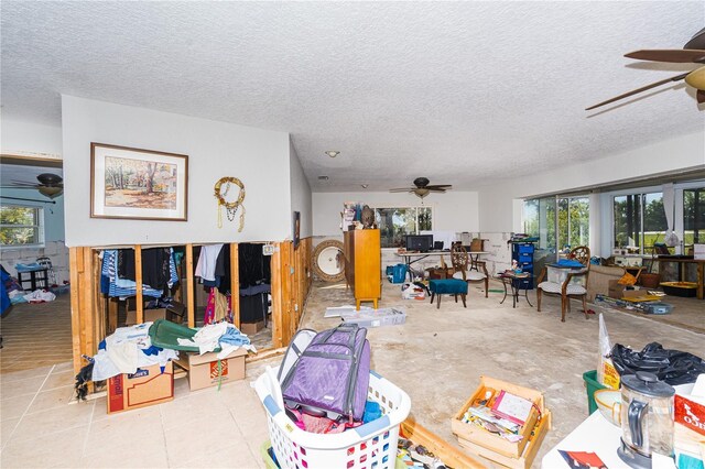 misc room with a healthy amount of sunlight, a textured ceiling, and ceiling fan