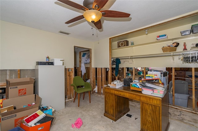 office space featuring visible vents, a textured ceiling, concrete floors, and a ceiling fan