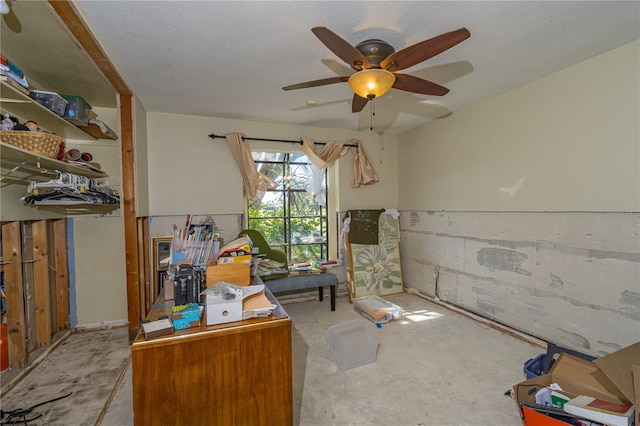 home office featuring unfinished concrete floors, a textured ceiling, and a ceiling fan