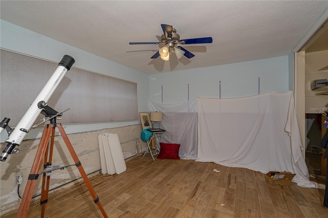 interior space featuring a textured ceiling, wood finished floors, and a ceiling fan